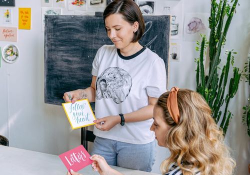 Instructor showing a pose to a student in a studio